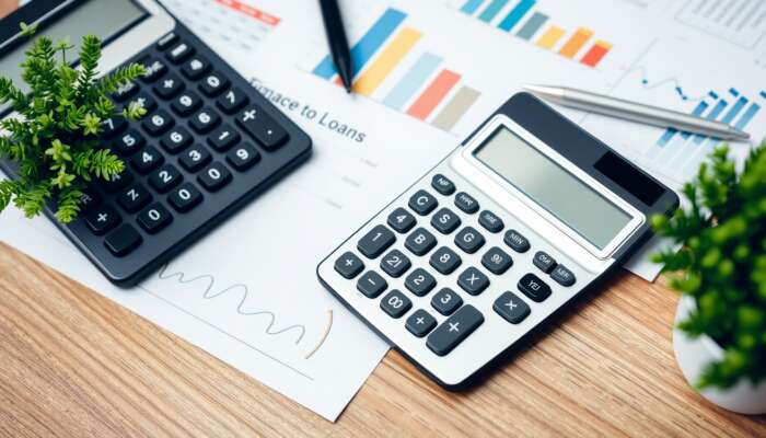 Calculator on a wooden table with financial documents and a pen, representing budgeting and financial planning for installment loans.