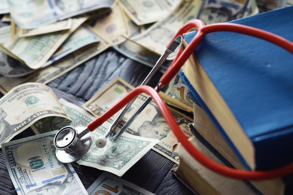 Stethoscope and textbooks on a pile of US dollars on our service page, symbolizing the cost of healthcare or medical education.
